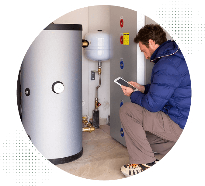 A man sitting in front of a water heater.