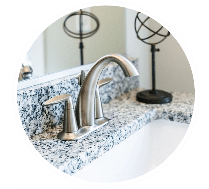 A bathroom sink with marble counter top and mirror.