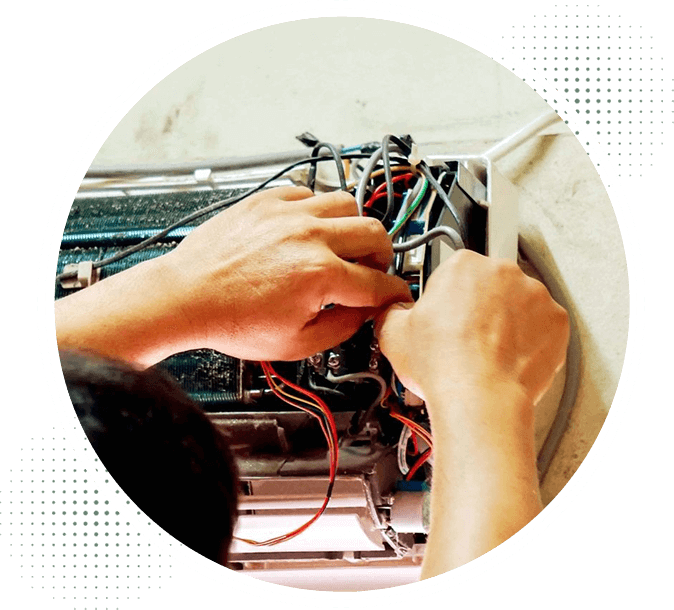 A person working on wires in front of an oven.